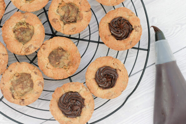filling cookie cups with ganache.